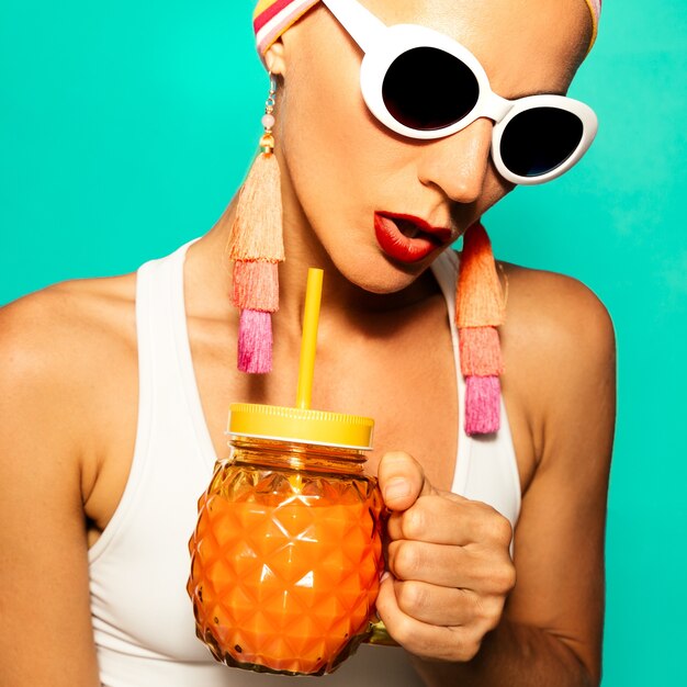 Fille de vacances élégante dans un look de plage à la mode et un cocktail de smoothie. Ambiance de fête sur la plage