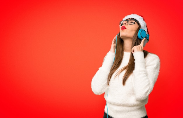 Fille avec les vacances de Noël, écouter de la musique avec des écouteurs