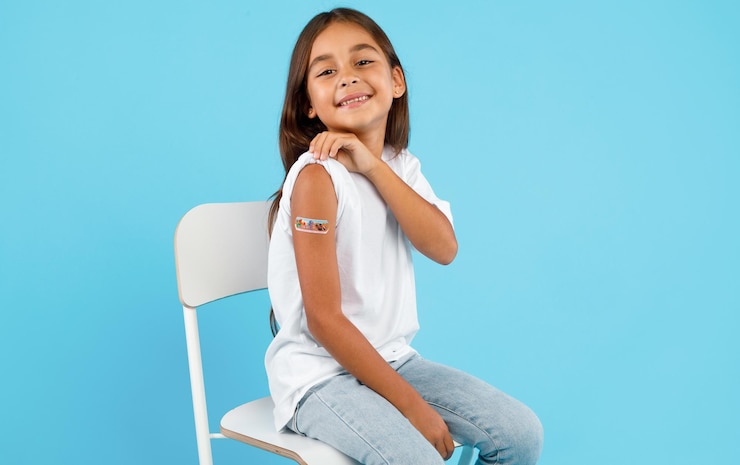 Photo fille vaccinée heureuse montrant le bras après la vaccination arrière-plan bleu