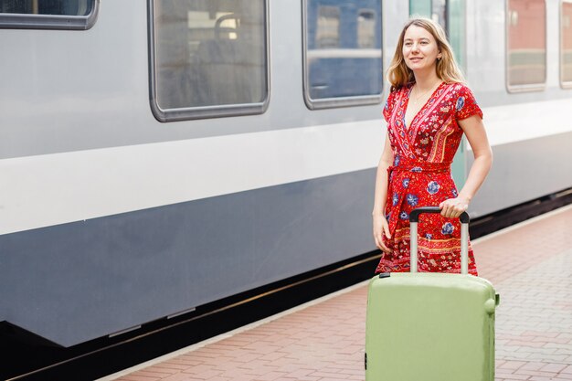 Fille avec une valise à la gare