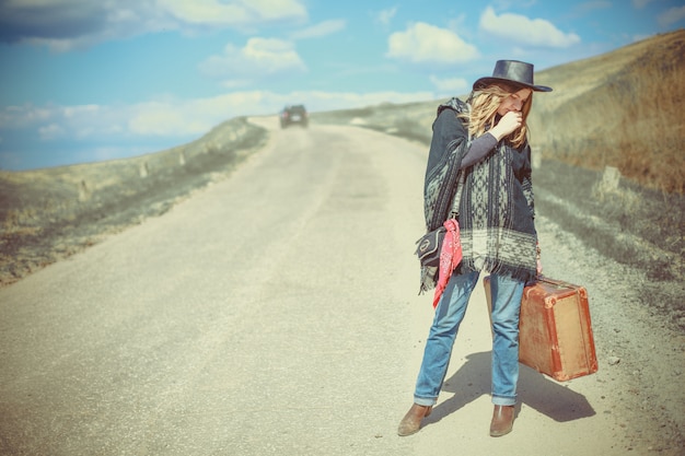 Photo fille avec une valise sur la route