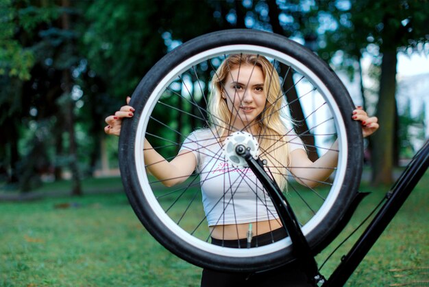 Fille avec un vélo dans le parc