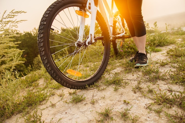 Fille en vélo de montagne sur le sentier sur un beau lever de soleil