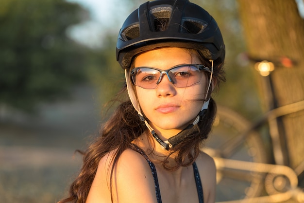 Fille sur un vélo de montagne sur tout-terrain beau portrait d'une fille cycliste monte un vélo en carbone moderne