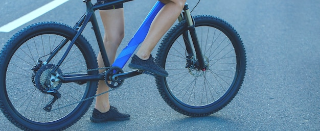 Fille sur un vélo de montagne sur tout-terrain Fille de remise en forme monte un vélo de montagne moderne en fibre de carbone