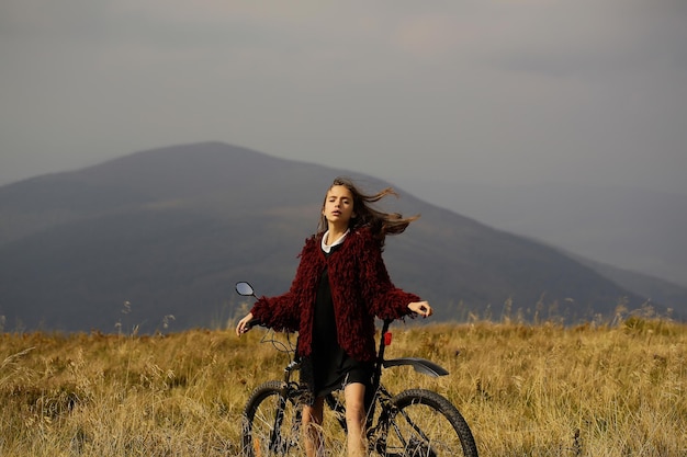 Fille avec vélo en montagne