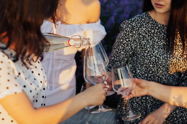 fille versant du vin blanc dans des verres au pique-nique en plein air d'été