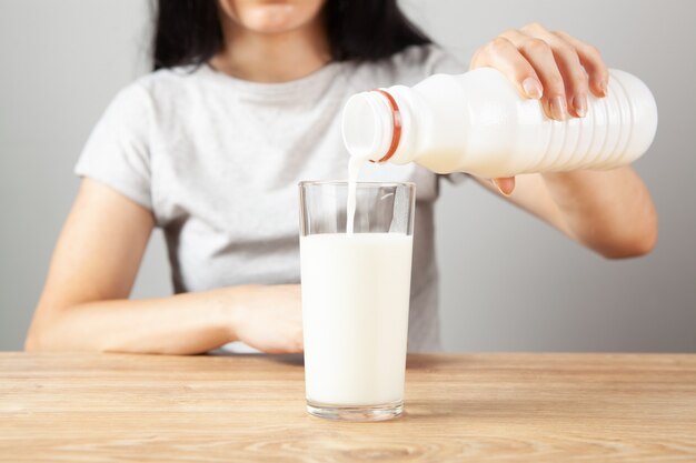 La fille verse du lait dans un verre