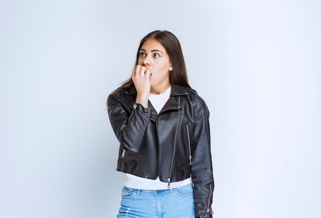 Fille en veste de cuir a l'air effrayée et terrifiée.