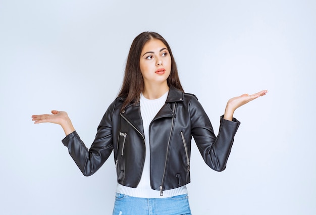 Fille en veste de cuir donnant des explications.