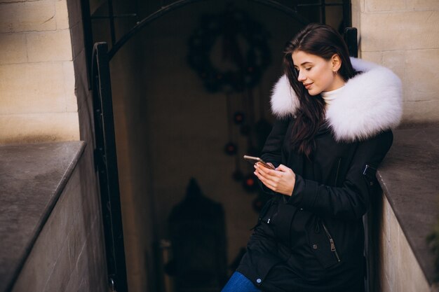 Fille en veste de fourrure, parler au téléphone à l&#39;extérieur