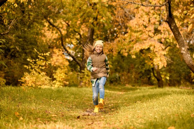 Une fille en vêtements chauds jouant dans le parc