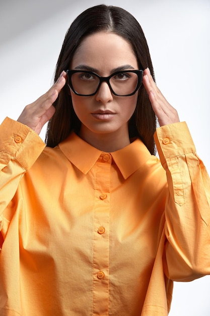 Fille en vêtements clairs et lunettes de soleil brune élégamment habillée sur fond gris sur fond gris lunettes publicitaires copies de gros plan de l'espace