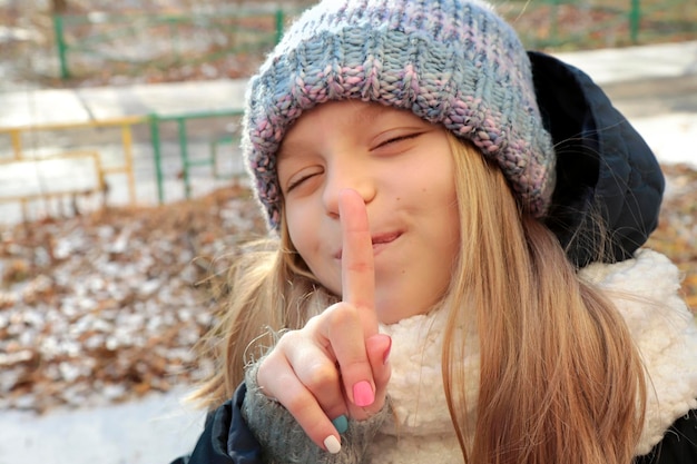 Une fille en vêtements d'hiver avec une manucure multicolore