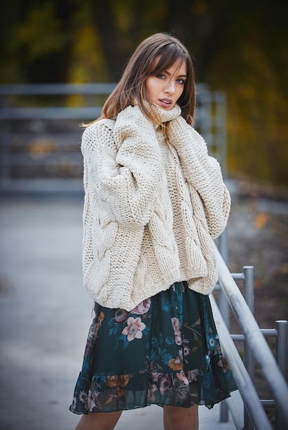 Une fille en vêtements de marque marche dans un parc en automne