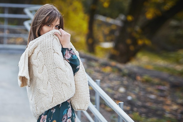 Une fille en vêtements de marque marche dans un parc en automne