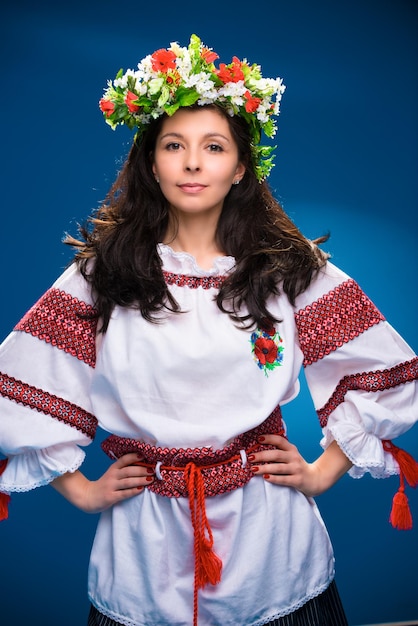 Une fille en vêtements nationaux d'une femme ukrainienne sur fond bleu.