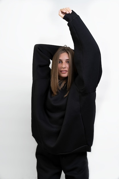 Photo fille en vêtements de sport chauds posant debout sur un fond blanc