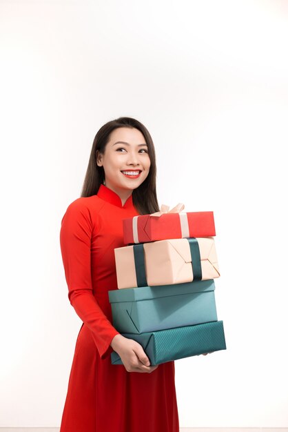 Fille vietnamienne à ao dai avec des coffrets cadeaux sur blanc