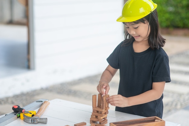 Les filles asiatiques jouant comme casque d'ingénieur sourient et sont heureuses le week-end.