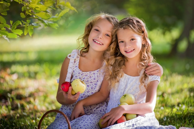 filles assis sur un banc et tenant des pommes