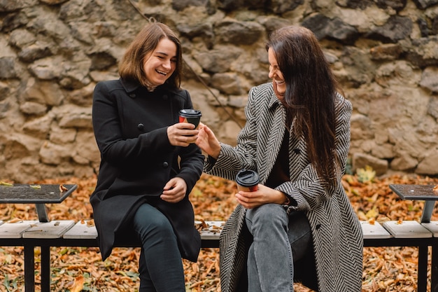 Filles Buvant Du Café Dans Le Parc. Amis Et Style De Vie