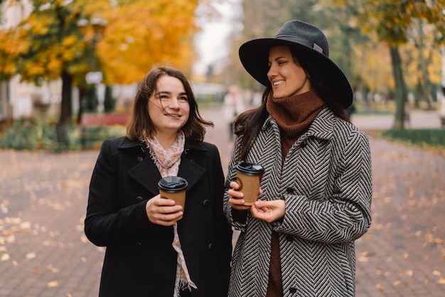 Filles buvant du café dans le parc