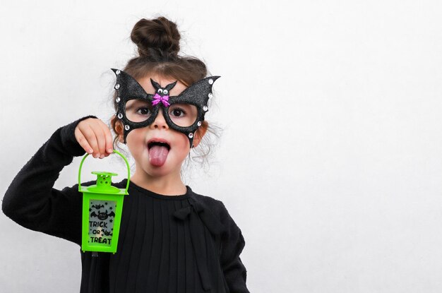 Filles caucasiennes en costume d'Halloween avec masque de chauve-souris et lanterne