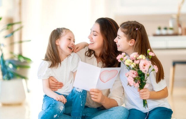 Filles donnant à la mère un bouquet de fleurs le jour de la fête des mères