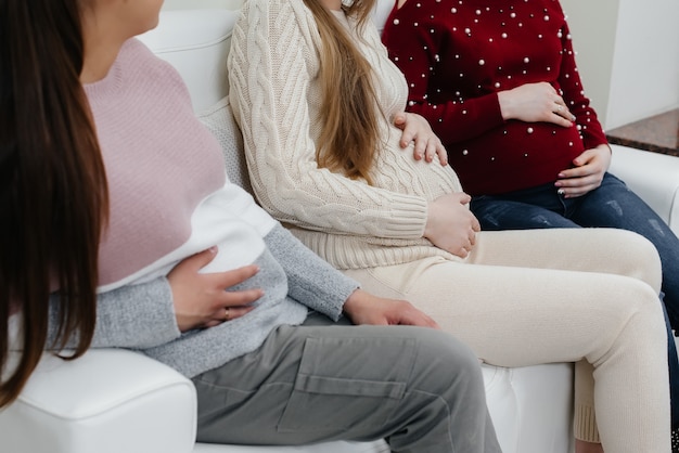 Les filles enceintes tiennent leur ventre avec leurs mains en gros plan. Classe prénatale de filles enceintes