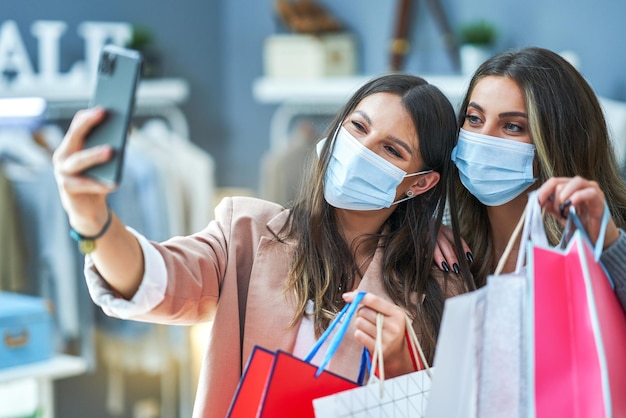 Filles faisant du shopping portant des masques prenant un selfie. photo de haute qualité