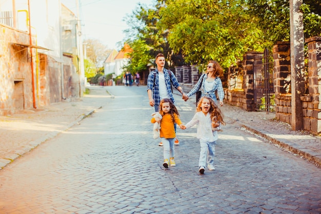 Filles heureuses courant vers la caméra tout en marchant avec leurs parents autour de la ville d'Uzhhorod, Ukraine