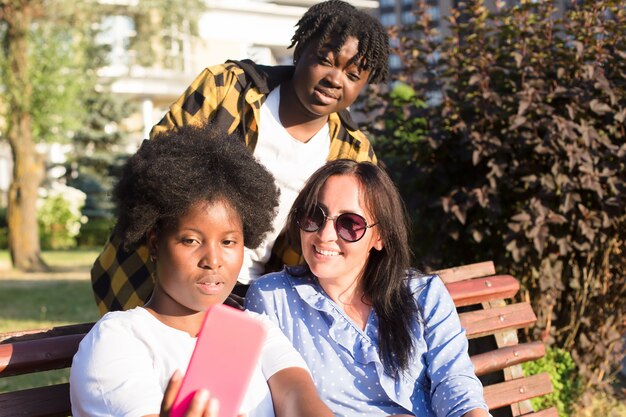 Des filles heureuses de différentes nationalités prennent des selfies en été.