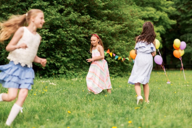 Des filles heureuses jouant au jeu d'étiquette à une fête d'anniversaire.