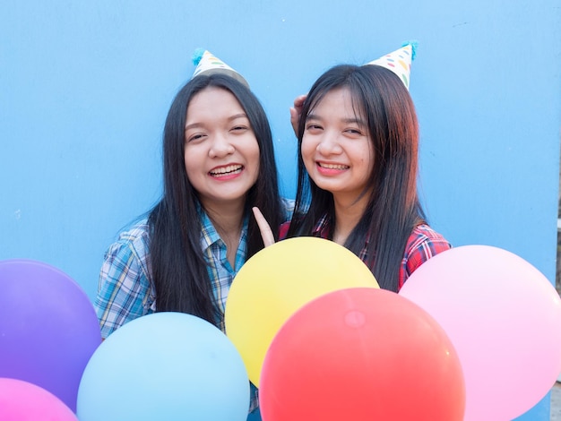 Photo les filles heureuses profitent de la fête avec des ballons colorés sur un fond bleu