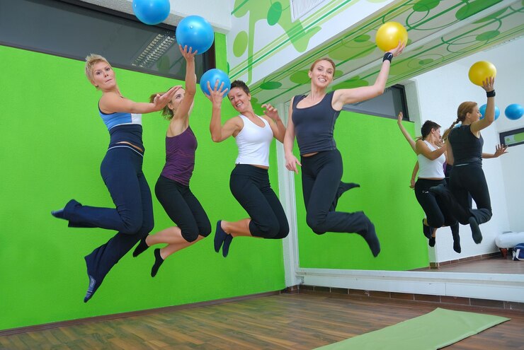filles heureuses sautant dans un centre de fitness