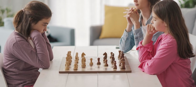 Filles jouant aux échecs ensemble à la maison