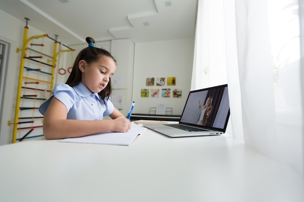 des filles joyeusement mignonnes excitées à l'aide de devoirs d'apprentissage informatique. enfant aime l'apprentissage en ligne en vacances à la maison.