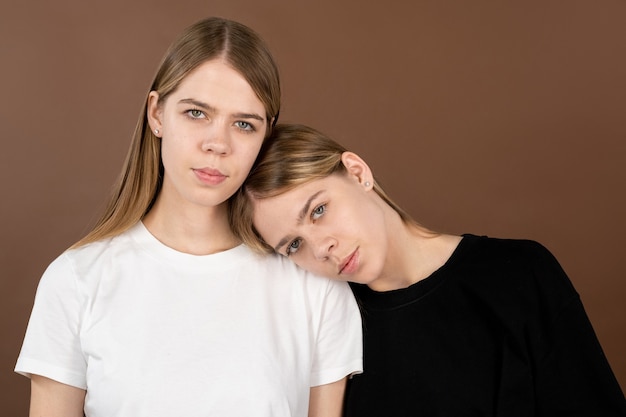 L'une des filles jumelles blondes gardant la tête sur l'épaule de sa sœur