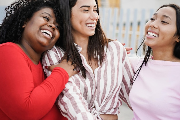 Des filles latines heureuses passent du temps ensemble en plein air autour de la ville - Focus sur le visage d'une fille africaine