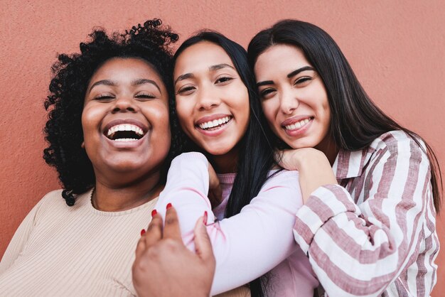 Filles latines s'amusant et s'embrassant en plein air