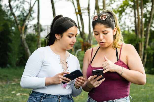 Filles latines se montrant les messages texte qu'elles ont sur leur téléphone portable