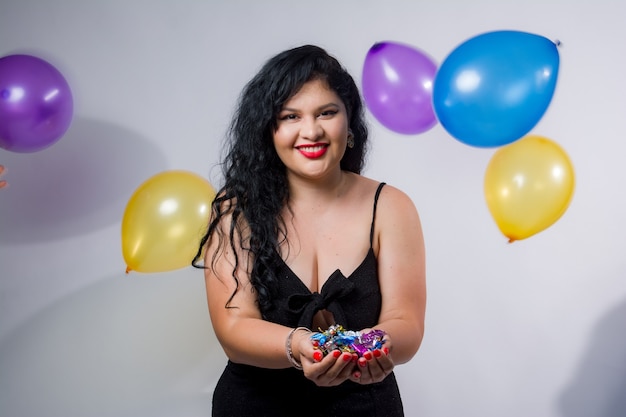 Filles latino-américaines posant et célébrant la nouvelle année avec des ballons et des confettis