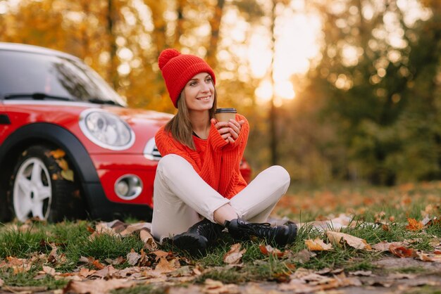 Filles marchant dans le parc d'automne dans le concept d'humeur d'automne de voiture rouge