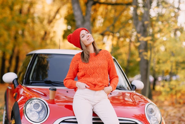 Filles marchant dans le parc d'automne dans le concept d'humeur d'automne de voiture rouge