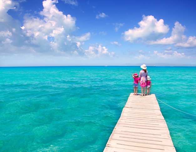 Filles et mère dans une jetée sur une plage tropicale