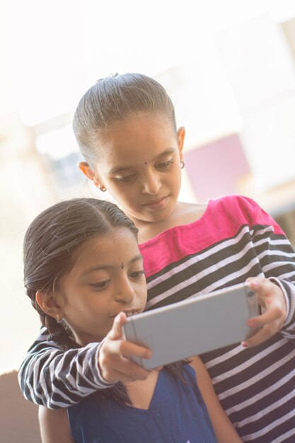 Photo des filles mignons qui utilisent un téléphone portable.