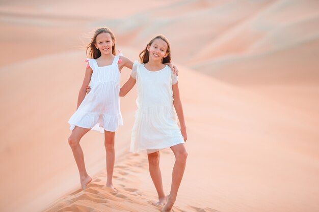 Filles parmi les dunes dans le grand désert des Émirats