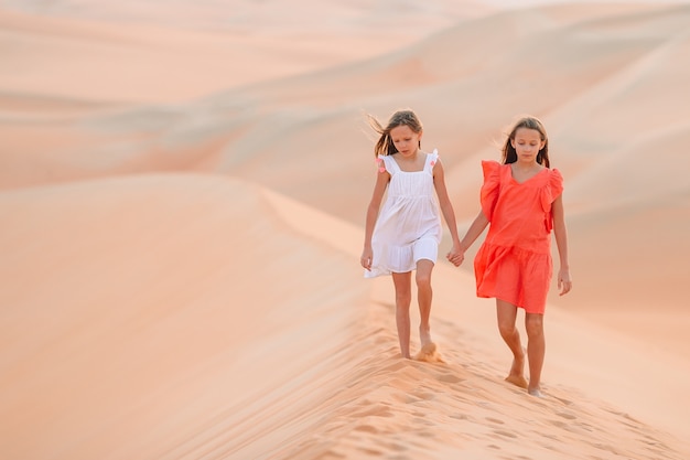 Filles parmi les dunes du désert de Rub al-Khali aux Émirats arabes unis