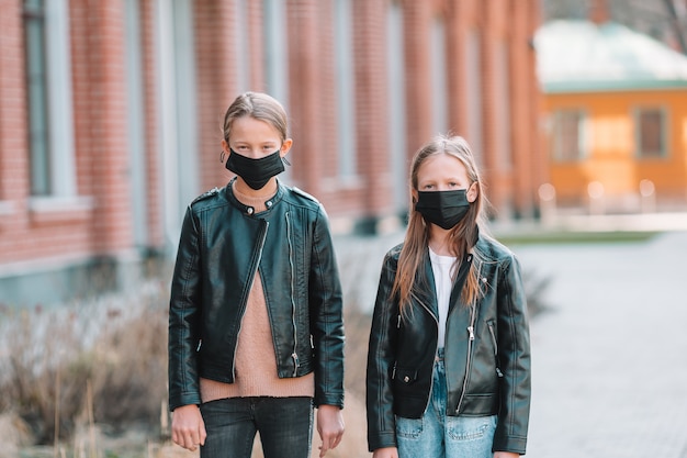 Les filles portant un masque sur un fond d'un bâtiment moderne,